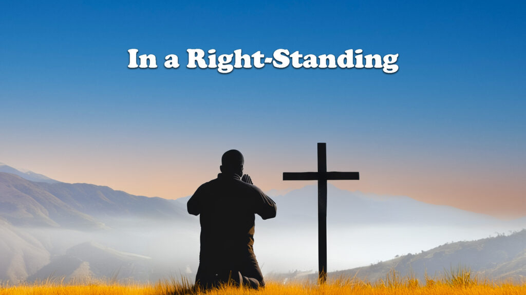 In a Right Standing image of man kneeling and worshipping in front of a cross with mountains in background